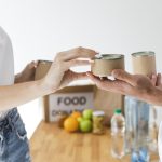 manos de personas realizando y recibiendo una donación de alimentos